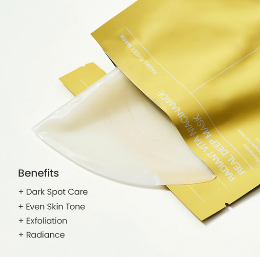 A close-up of a gold facial mask packet with a translucent white sheet partially pulled out, on a white background with text listing benefits such as dark spot care and even skin tone.